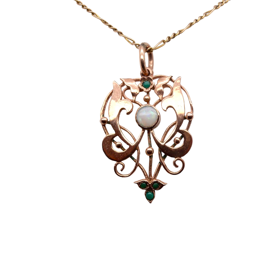 An elegant Edwardian-style pendant featuring a fancy openwork design, set with a round 5mm opal centre stone.