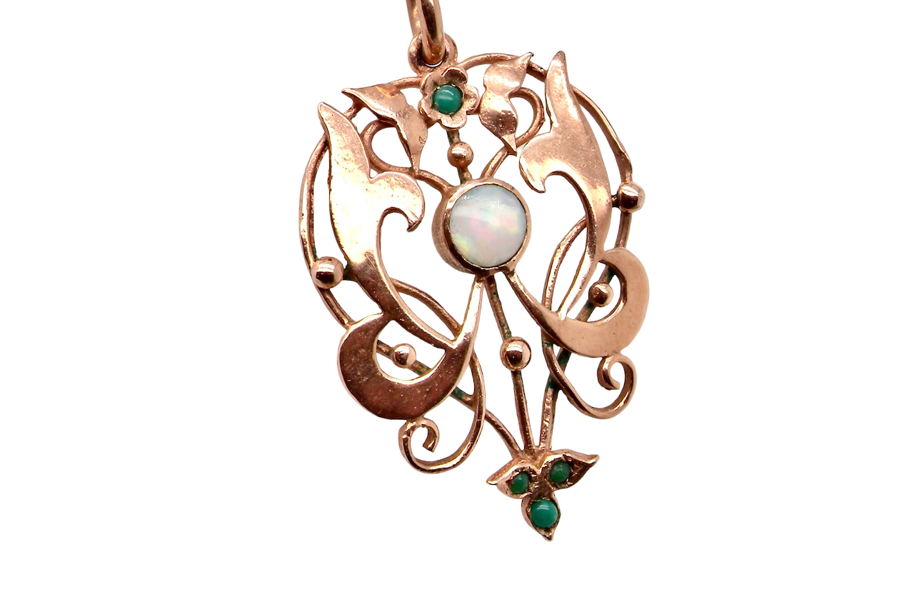 close view An elegant Edwardian-style pendant featuring a fancy openwork design, set with a round 5mm opal centre stone.