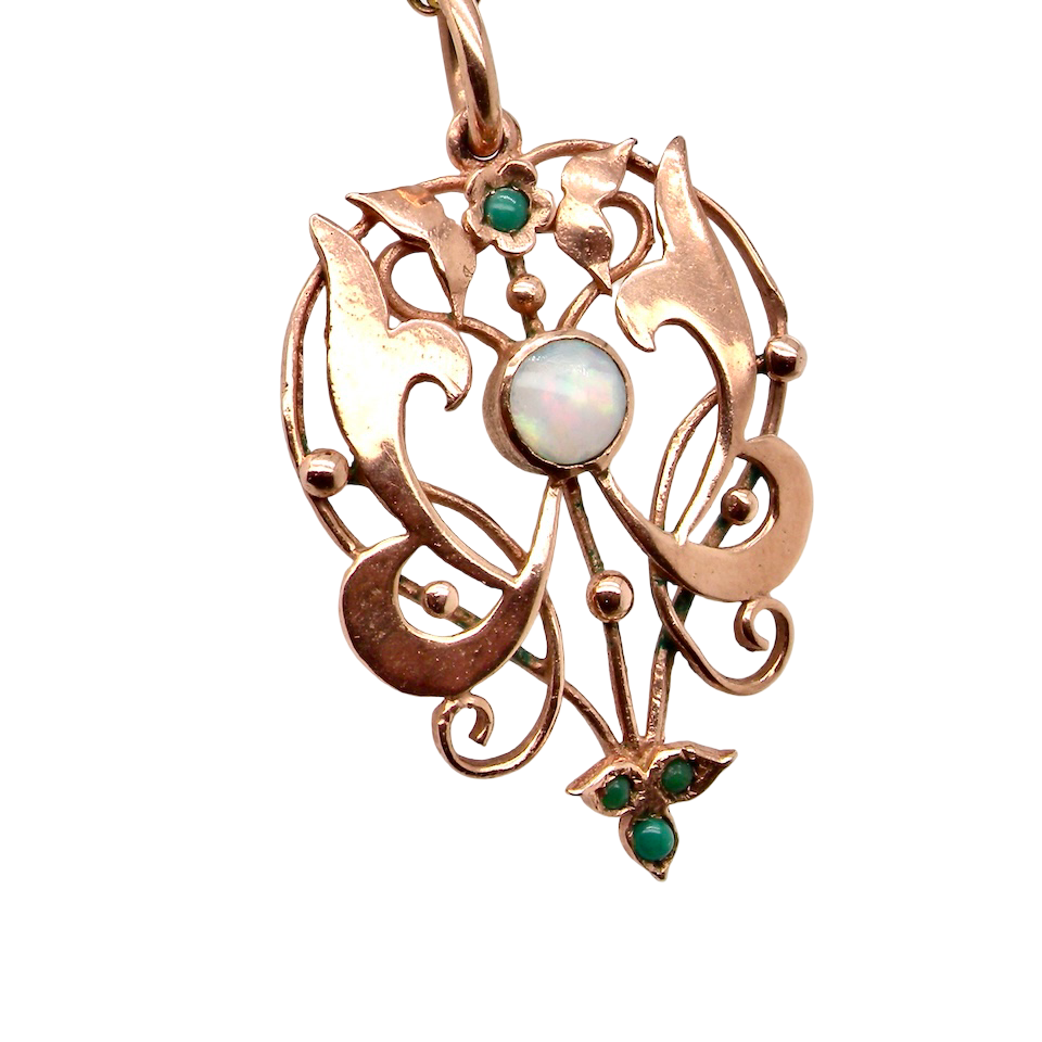 close view An elegant Edwardian-style pendant featuring a fancy openwork design, set with a round 5mm opal centre stone.