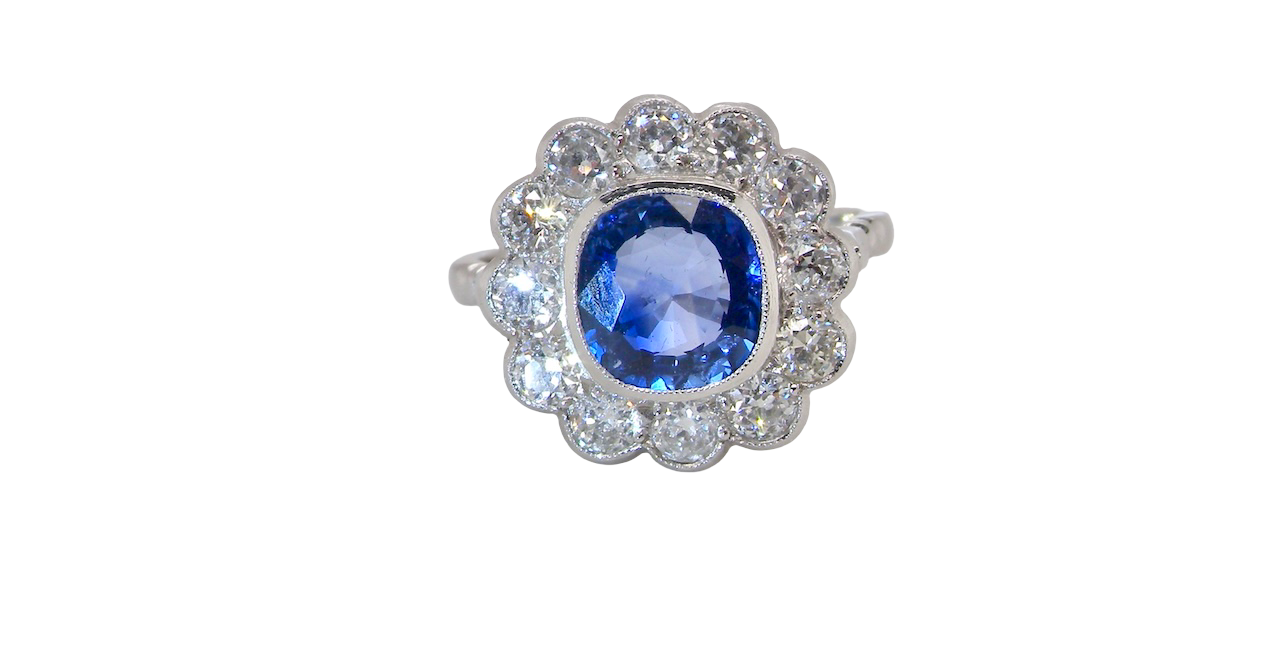 An elegant and timeless cluster ring, centrally set with a beautiful mid to deep blue cushion-cut sapphire, (estimated 2.00 carats).