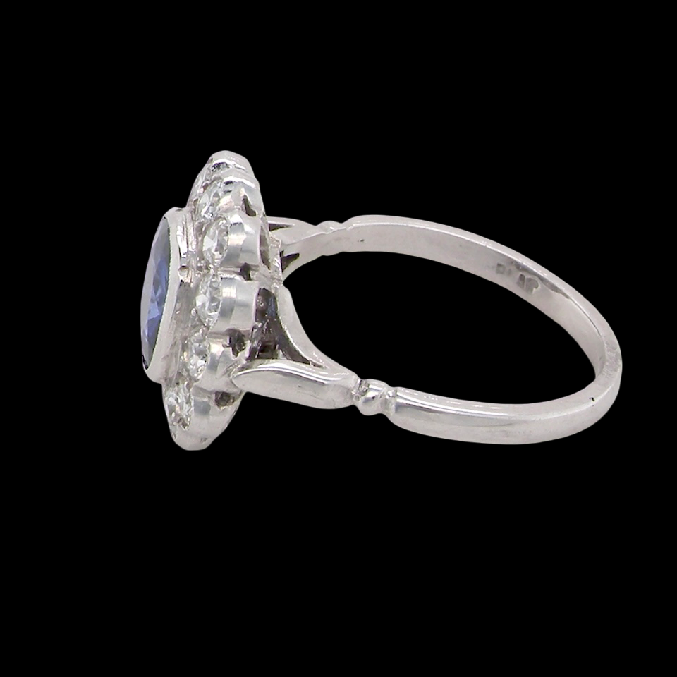 An elegant and timeless cluster ring, centrally set with a beautiful mid to deep blue cushion-cut sapphire, measuring approximately 8 x 8mm (estimated 2.00 carats). side
