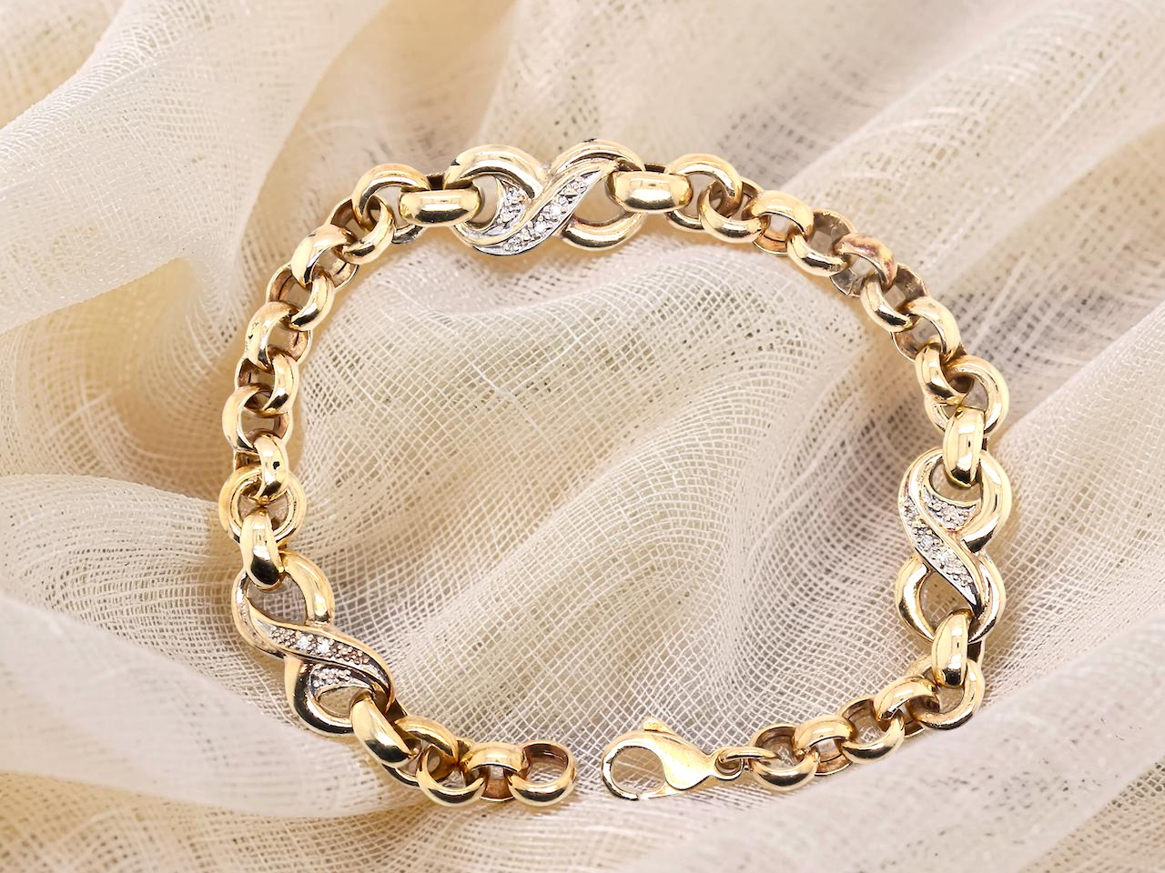An elegant and wearable 9 carat gold bracelet featuring distinctive diamond-set “kiss” style links, beautifully balanced with belcher connectors.