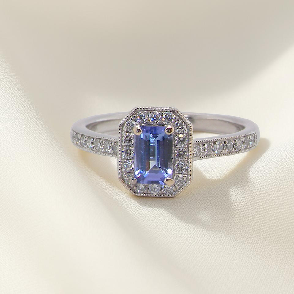 An elegant cluster ring that features to the centre a rectangular tanzanite gemstone that measures 6x4mm (est 0.50 carats)