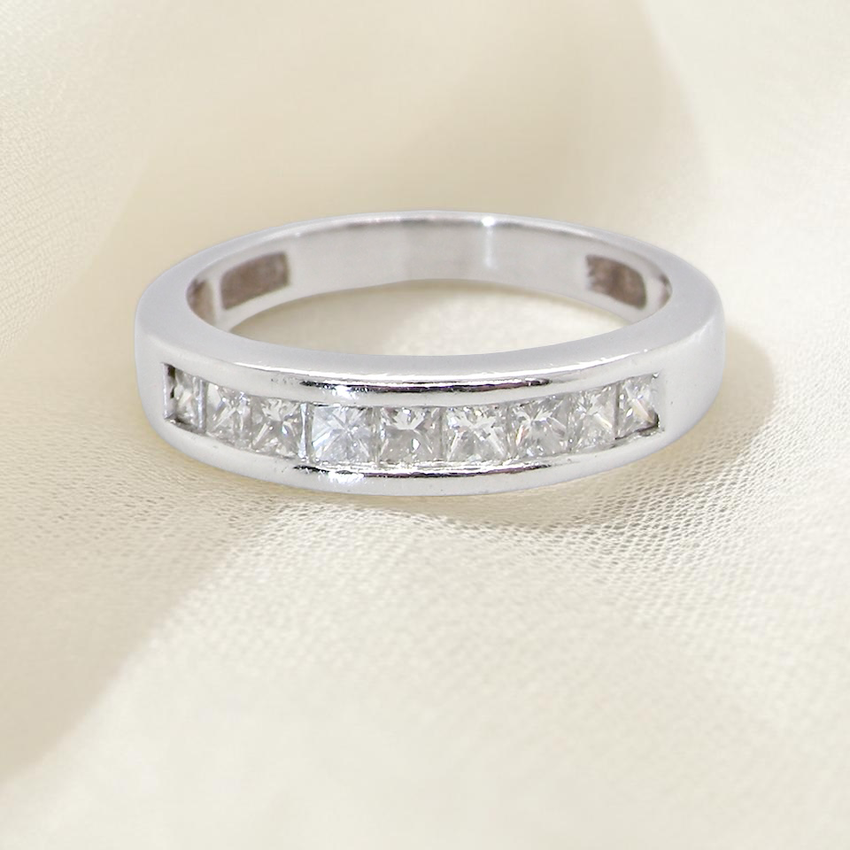 An elegant half-hoop eternity ring set with nine princess-cut white diamonds, each measuring approximately 2.5mm, with a total diamond weight of 0.90 carats.