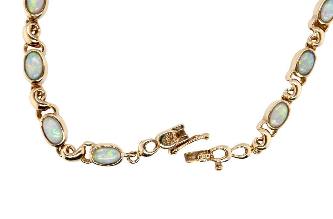 An elegant line bracelet set with fourteen oval opals, each measuring approximately 5 x 3 mm, displaying a lively play of colour.