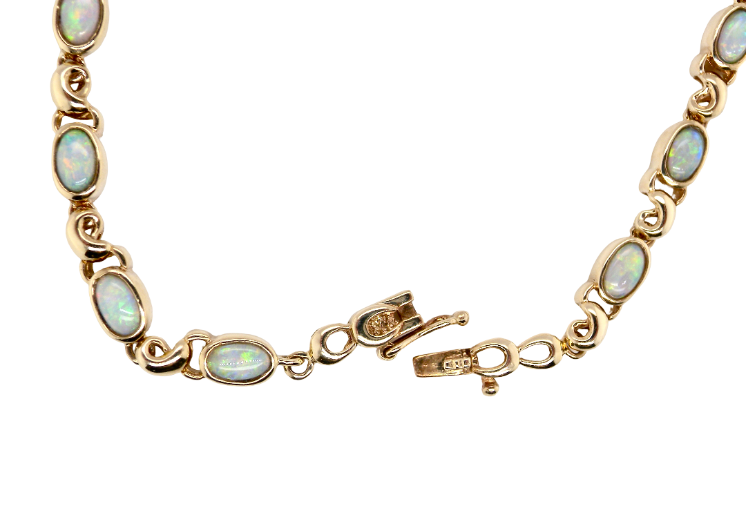 An elegant line bracelet set with fourteen oval opals, each measuring approximately 5 x 3 mm, displaying a lively play of colour.