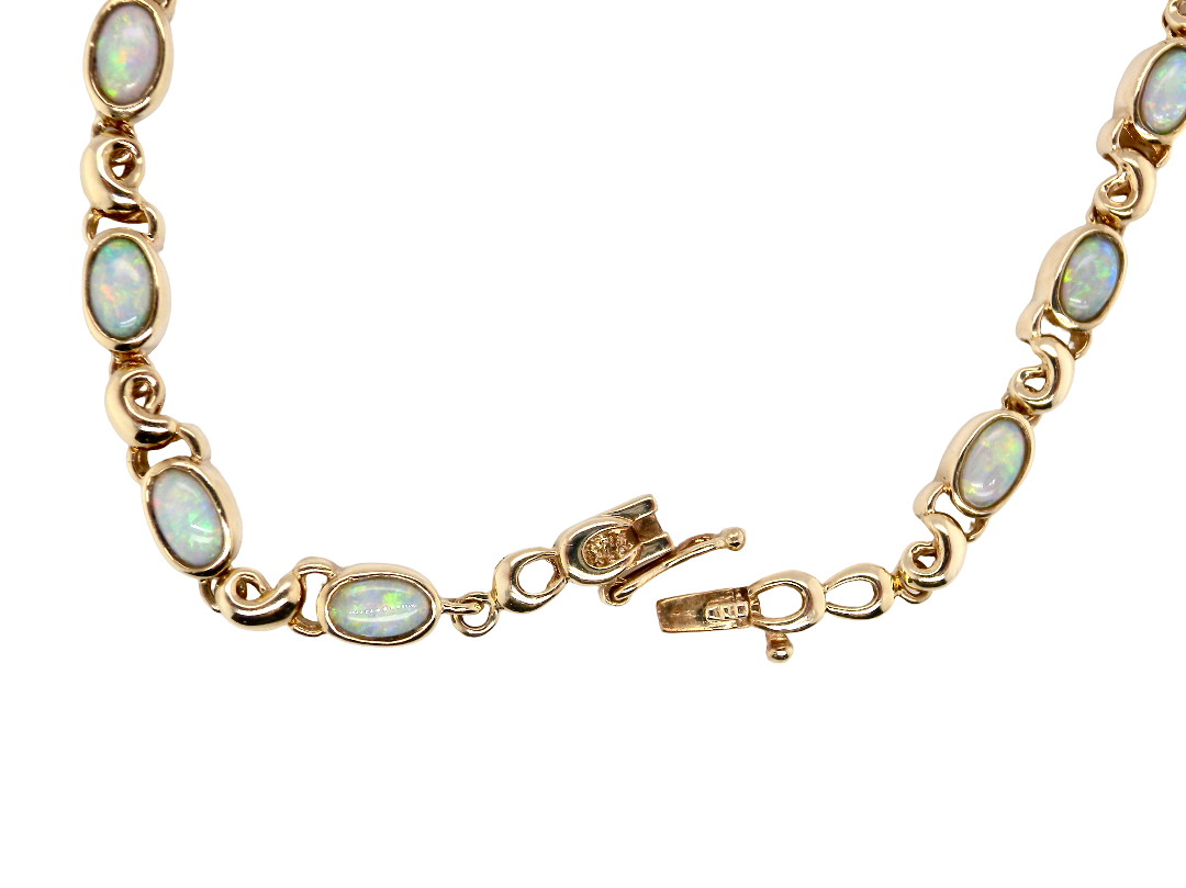 An elegant line bracelet set with fourteen oval opals, each measuring approximately 5 x 3 mm, displaying a lively play of colour.