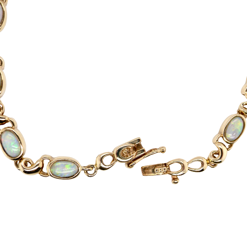 An elegant line bracelet set with fourteen oval opals, each measuring approximately 5 x 3 mm, displaying a lively play of colour.