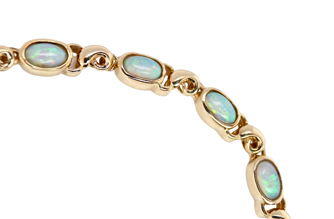 An elegant line bracelet set with fourteen oval opals, each measuring approximately 5 x 3 mm, displaying a good and lively play of colour.