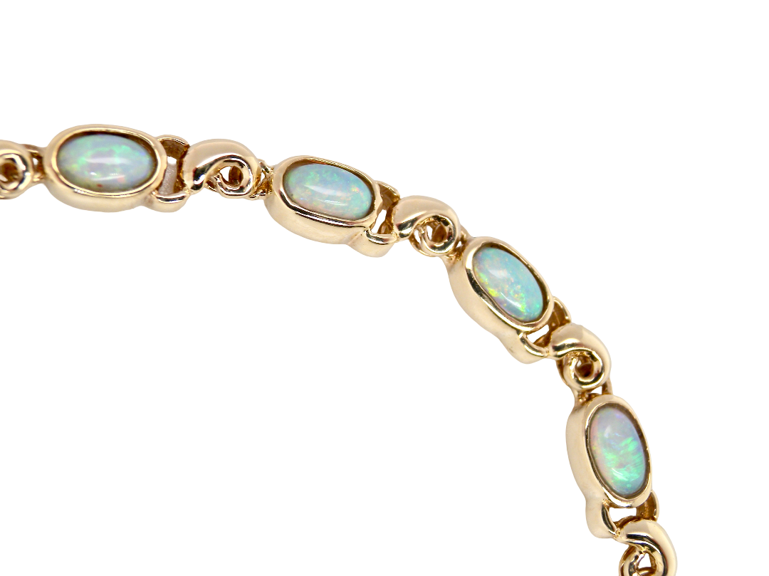 An elegant line bracelet set with fourteen oval opals, each measuring approximately 5 x 3 mm, displaying a good and lively play of colour.