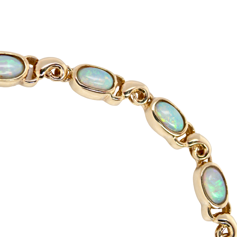 An elegant line bracelet set with fourteen oval opals, each measuring approximately 5 x 3 mm, displaying a good and lively play of colour.