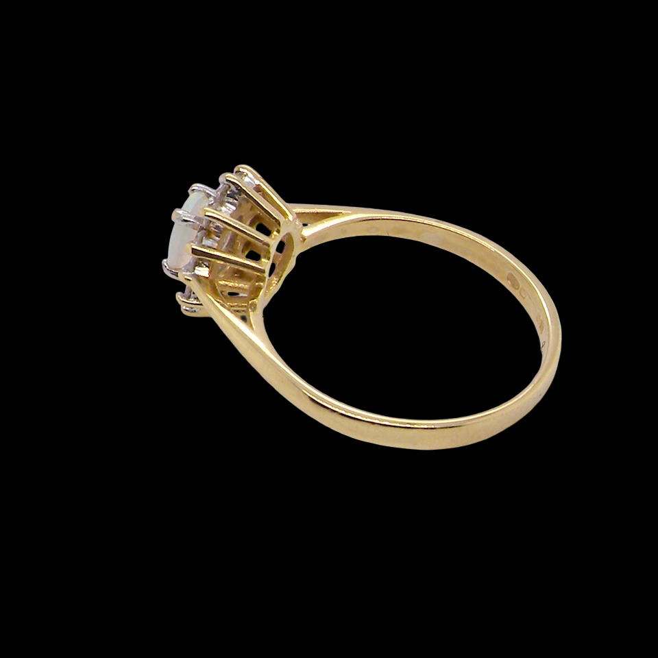 An elegant cluster ring featuring a white opal centre stone measuring 6 × 4mm, displaying a lively and attractive play of colour. side