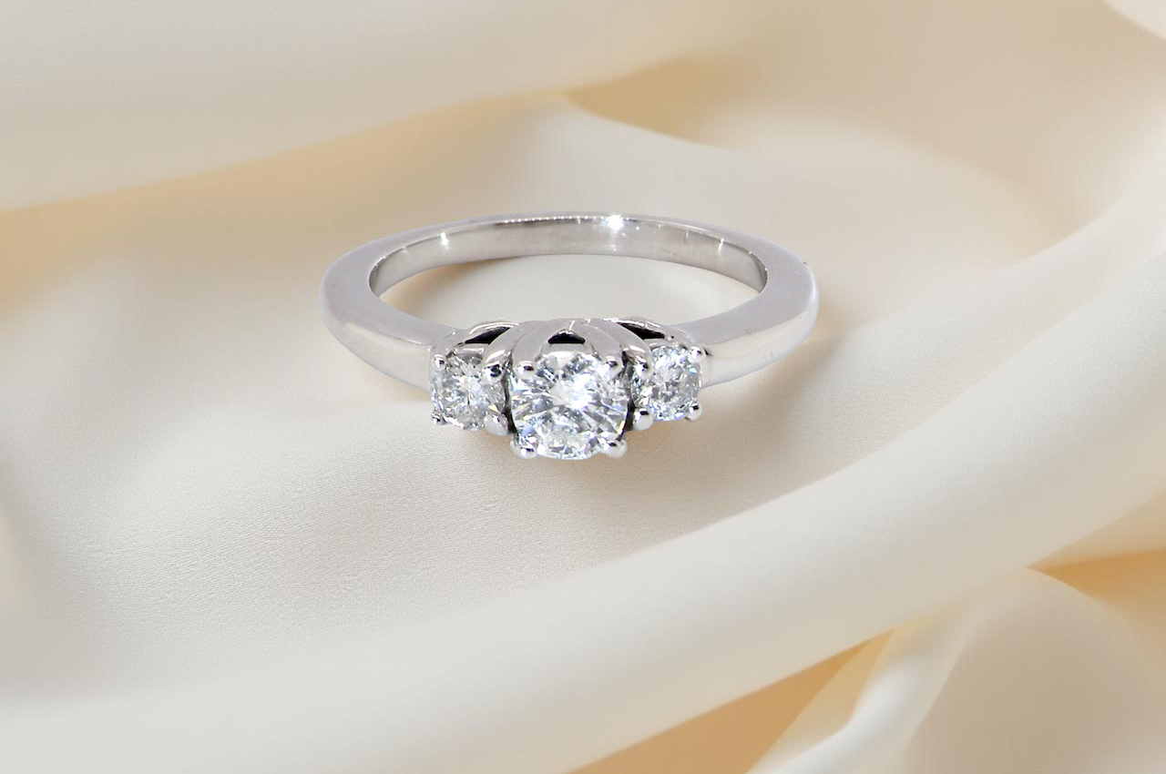 An elegant trilogy ring set with three white diamonds,