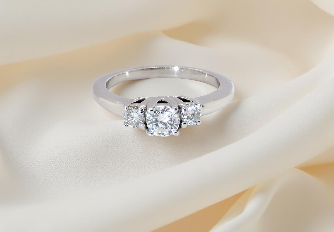 An elegant trilogy ring set with three white diamonds,