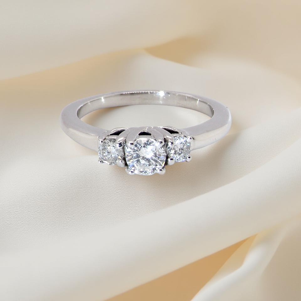 An elegant trilogy ring set with three white diamonds,