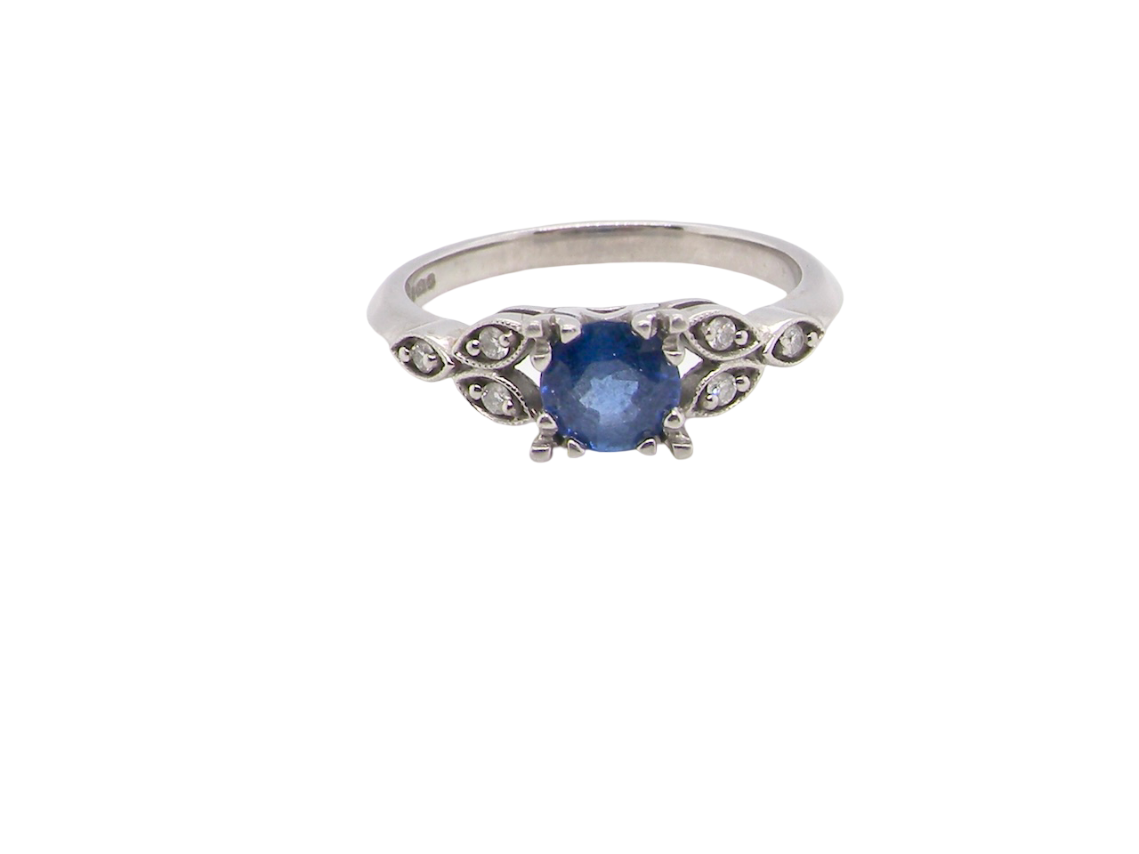 An elegant vintage-style platinum ring showcasing a beautifully proportioned round sapphire with a soft mid to light cornflower blue hue. The sapphire measures 5.6mm in diameter (approx. 0.80 carats)
