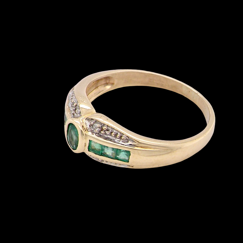 An emerald and diamond dress ring