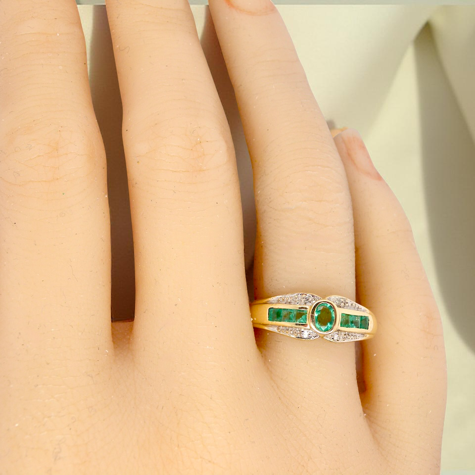 An emerald and diamond dress ring