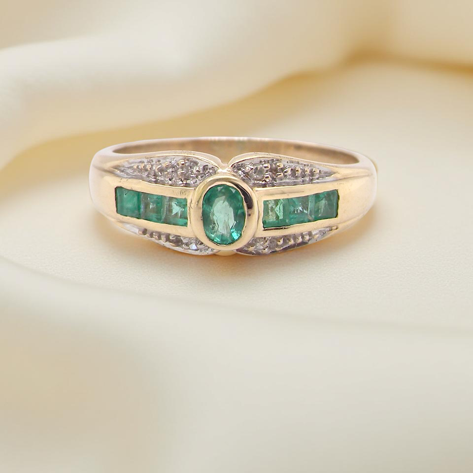 An emerald and diamond dress ring