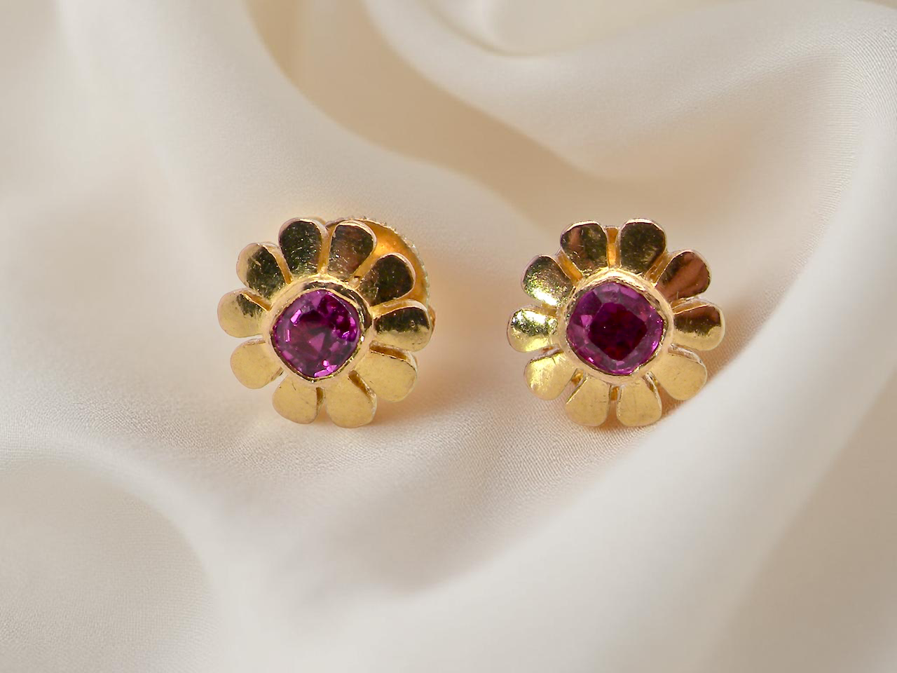 An exceptional pair of ruby earrings.Each earring is centred with a cushion-shaped ruby measuring 3.6–3.8mm,