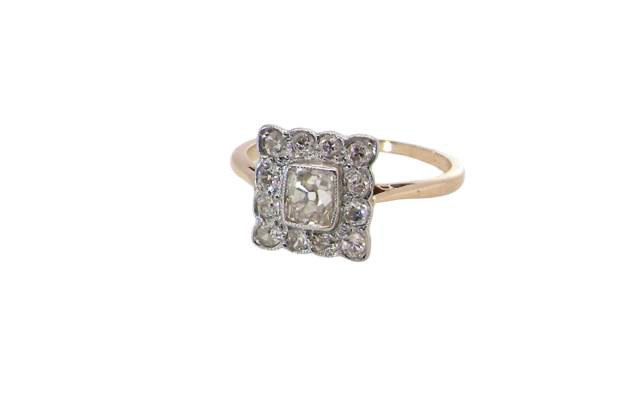 An exquisite Art Deco diamond cluster ring, beautifully handcrafted and rich in period charm.
At its centre sits a striking rectangular cut diamond measuring approximately 5 x 4.8mm, estimated at 0.50 carats,