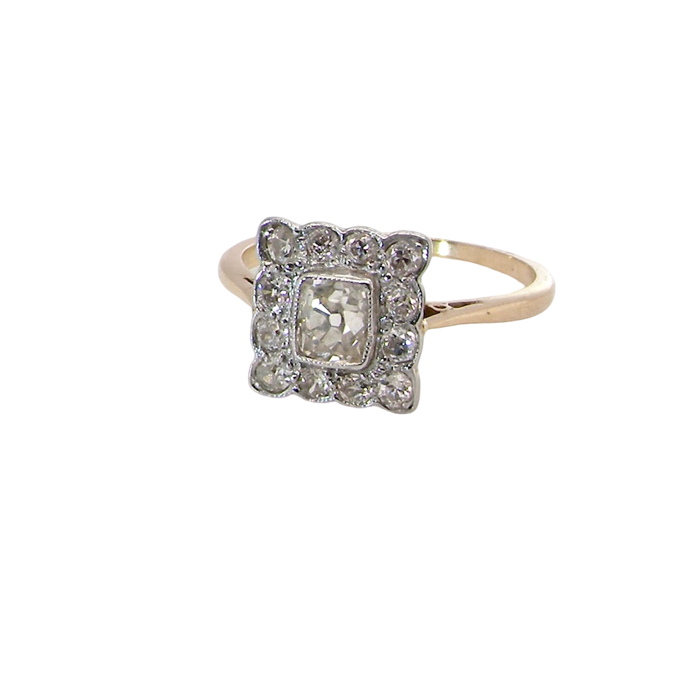 An exquisite Art Deco diamond cluster ring, beautifully handcrafted and rich in period charm.
At its centre sits a striking rectangular cut diamond measuring approximately 5 x 4.8mm, estimated at 0.50 carats,