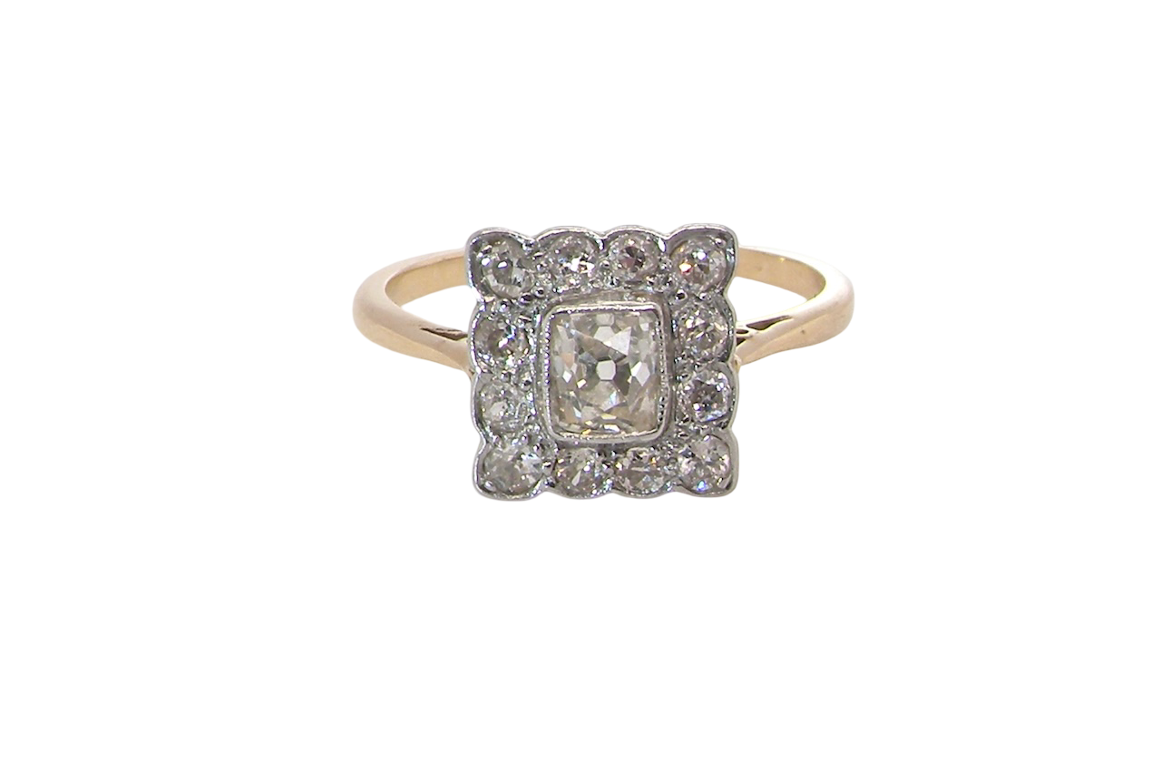 An exquisite Art Deco diamond cluster ring, beautifully handcrafted and rich in period charm.
At its centre sits a striking rectangular cut diamond measuring approximately 5 x 4.8mm, estimated at 0.50 carats,