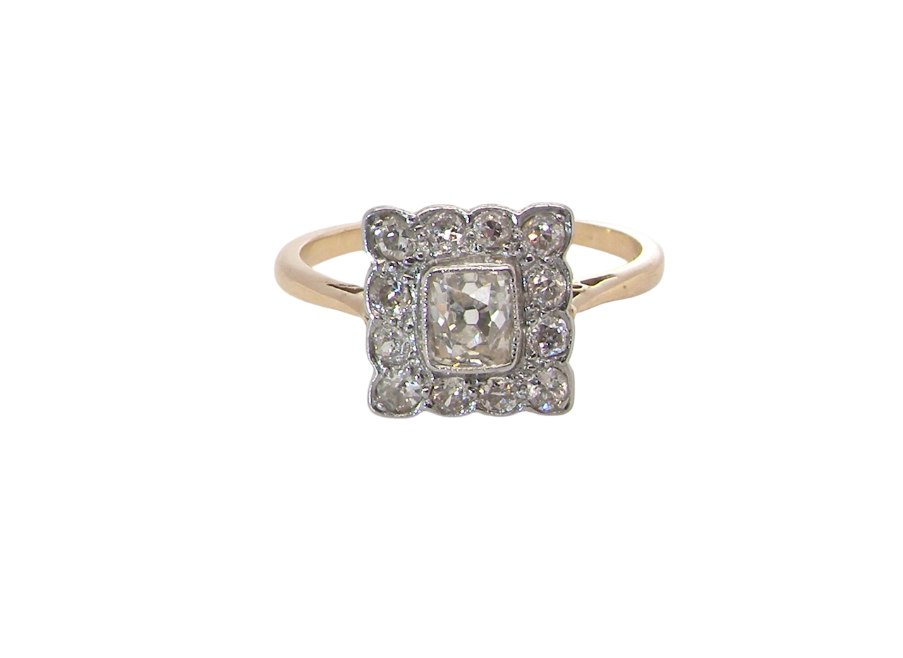 An exquisite Art Deco diamond cluster ring, beautifully handcrafted and rich in period charm.
At its centre sits a striking rectangular cut diamond measuring approximately 5 x 4.8mm, estimated at 0.50 carats,