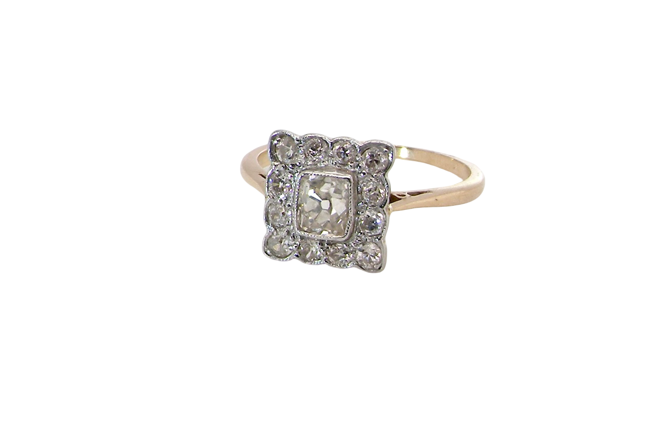 An exquisite Art Deco diamond cluster ring, beautifully handcrafted and rich in period charm.
At its centre sits a striking rectangular cut diamond measuring approximately 5 x 4.8mm, estimated at 0.50 carats,
