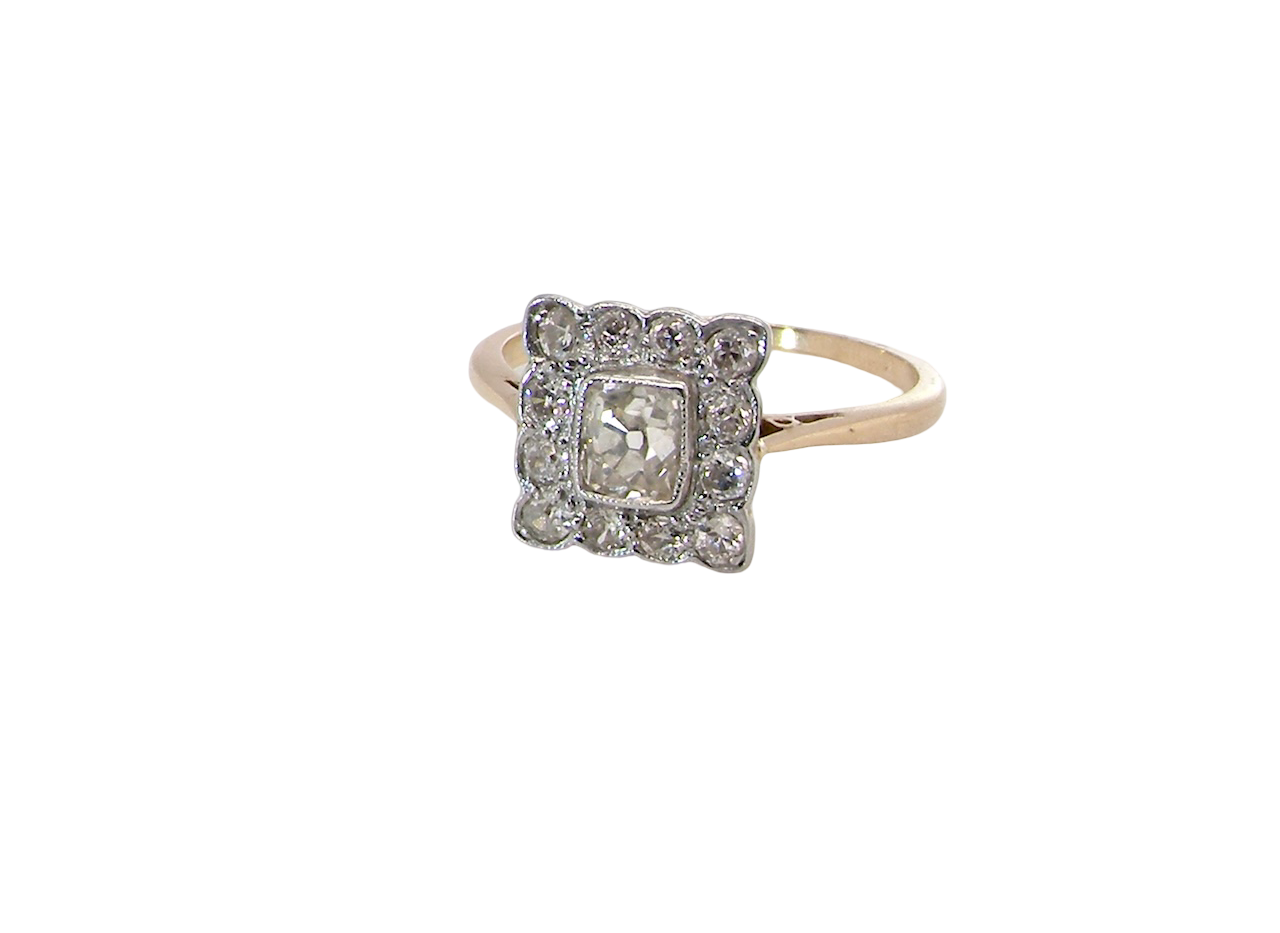 An exquisite Art Deco diamond cluster ring, beautifully handcrafted and rich in period charm.
At its centre sits a striking rectangular cut diamond measuring approximately 5 x 4.8mm, estimated at 0.50 carats,