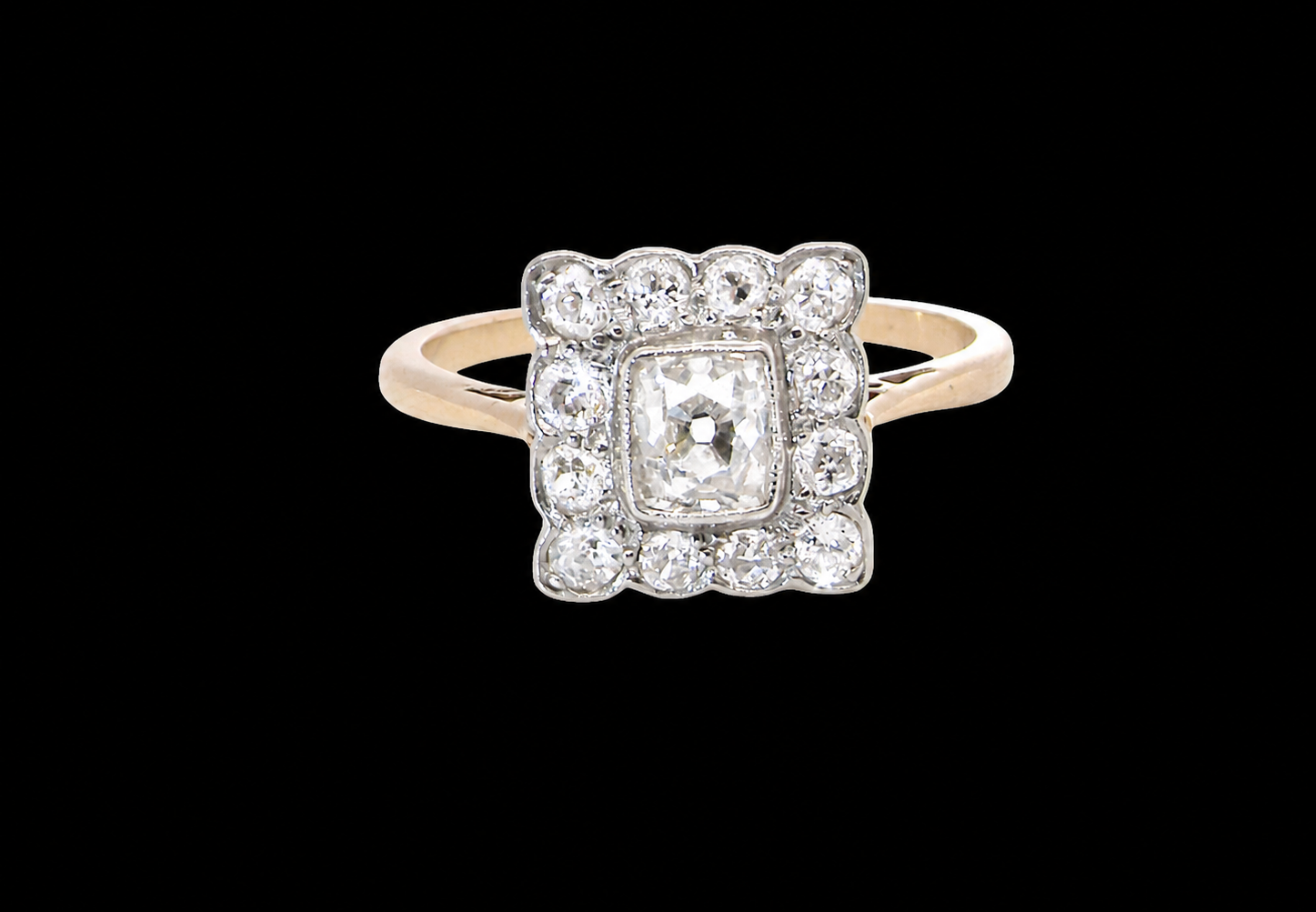 An exquisite Art Deco diamond cluster ring, beautifully handcrafted and rich in period charm.
At its centre sits a striking rectangular cut diamond