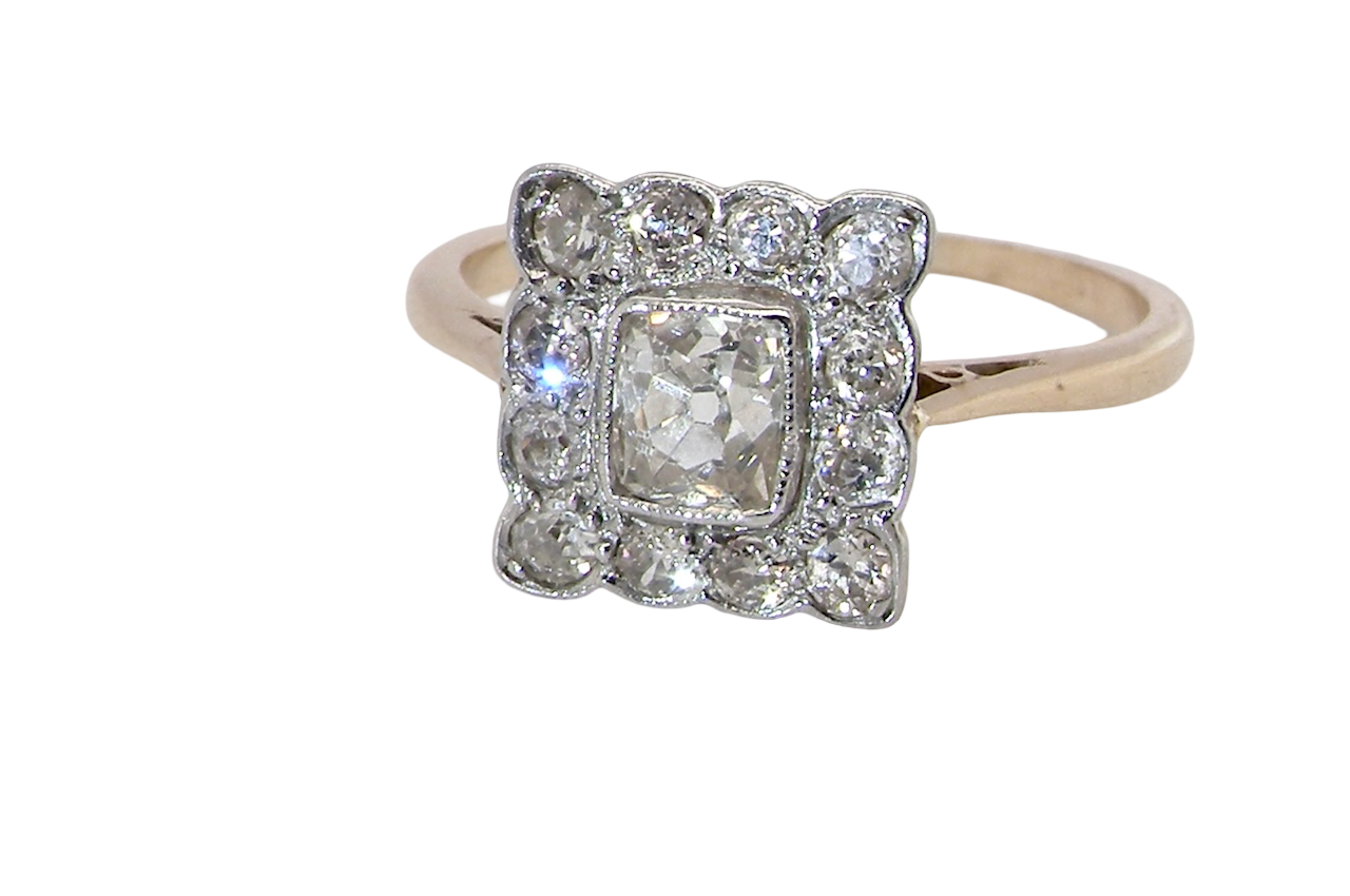 An exquisite Art Deco diamond cluster ring, beautifully handcrafted and rich in period charm.
At its centre sits a striking rectangular cut diamond measuring approximately 5 x 4.8mm, estimated at 0.50 carats,