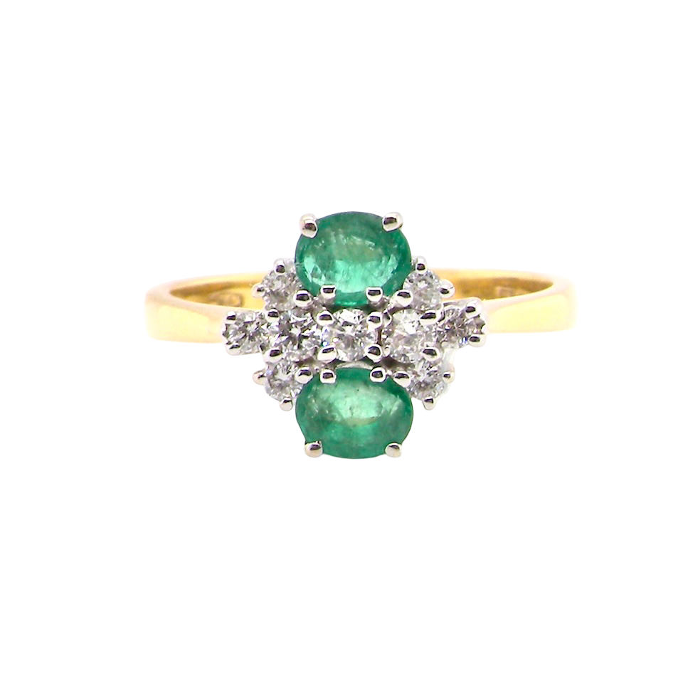 Gold ring with emeralds and diamonds on a white background