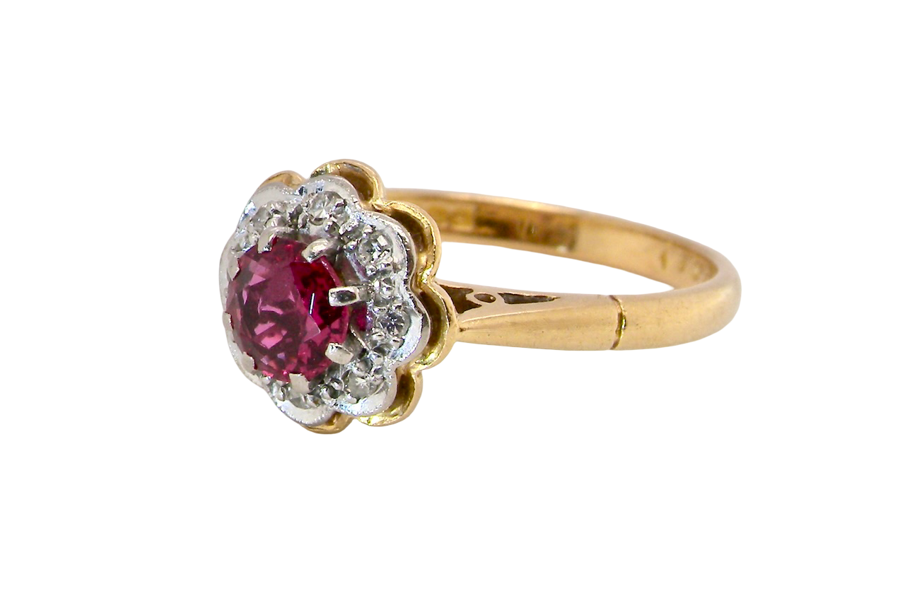 An exquisite vintage cluster ring centred around a 5 mm ruby,( 0.50 carats) side