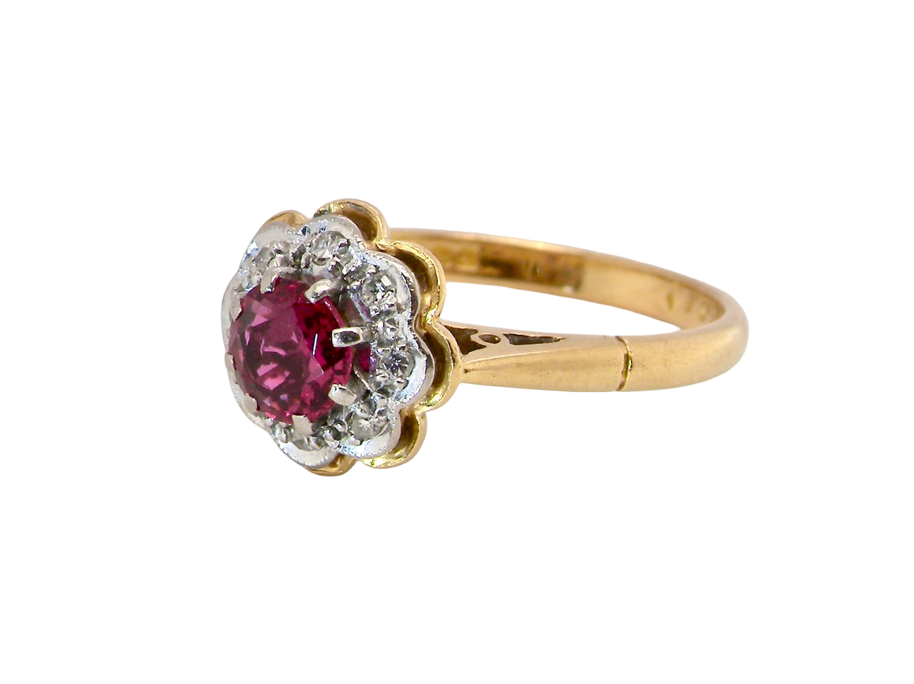 An exquisite vintage cluster ring centred around a 5 mm ruby,( 0.50 carats) side