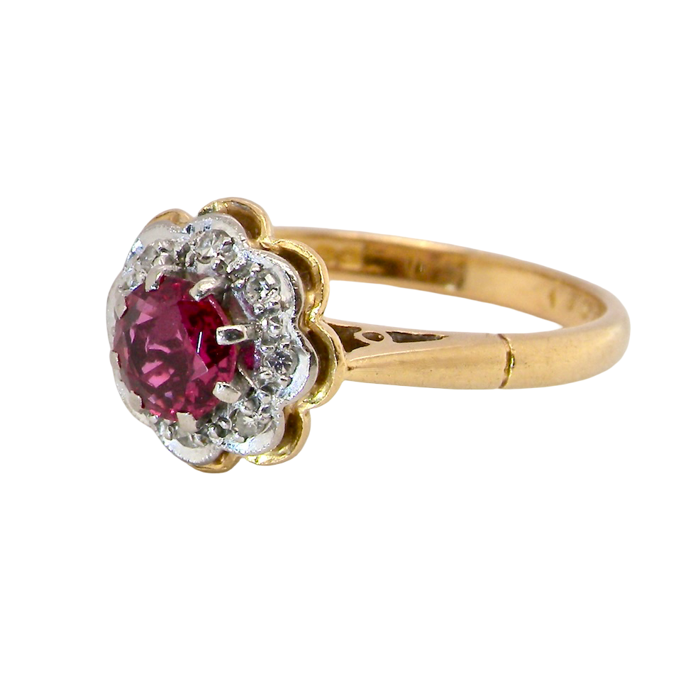 An exquisite vintage cluster ring centred around a 5 mm ruby,( 0.50 carats) side