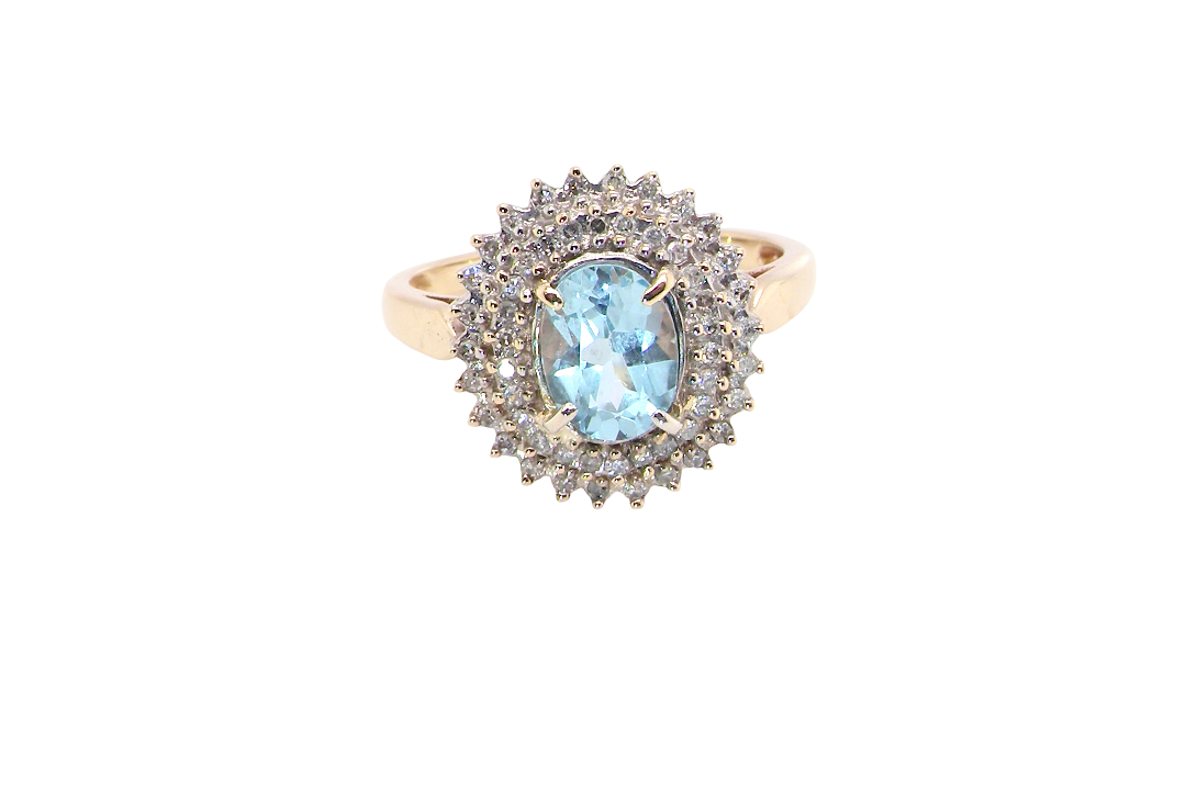 An impressive cluster ring that features to the centre an oval cut blue topaz gemstone, 8x6mm sky blue colour.
Complimented by an outer double halo of diamonds