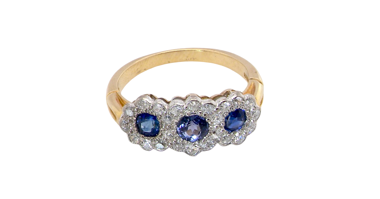 An impressive multi cluster ring. Set with three cornflower blue sapphires to each centre, 4.3mm, and each side a 3.3mm sapphire.