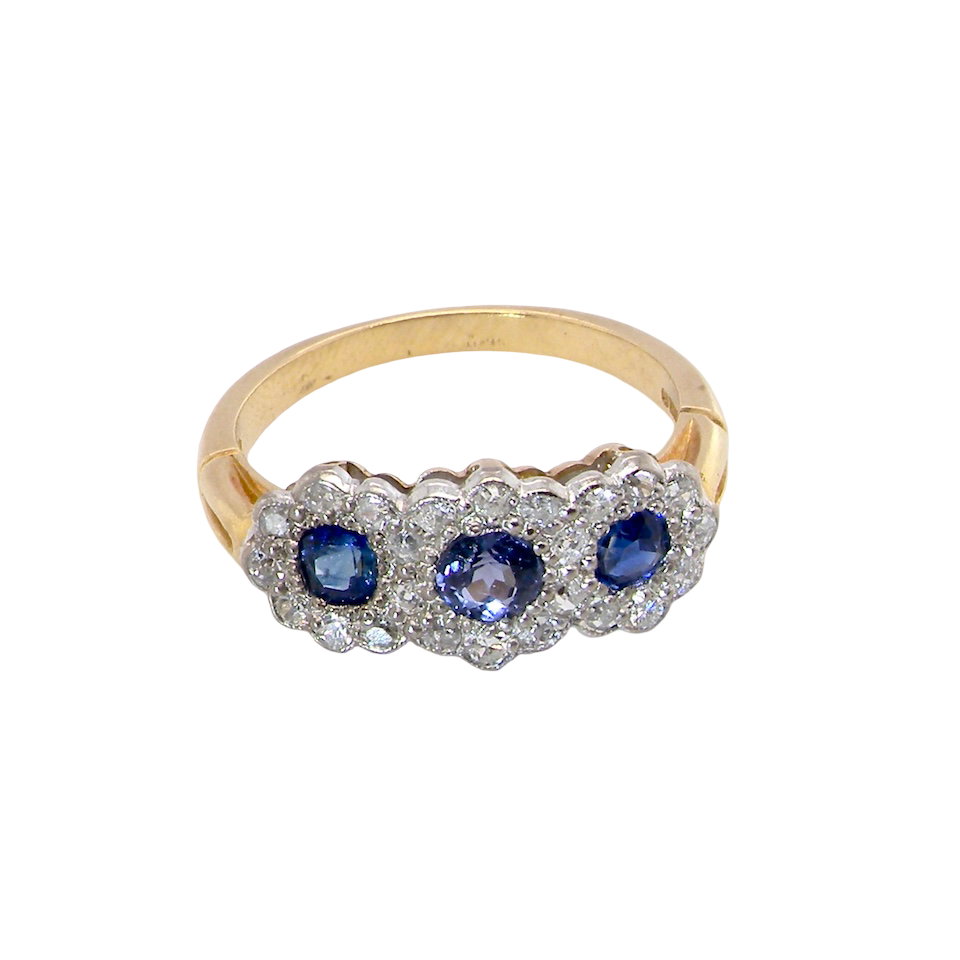 An impressive multi cluster ring. Set with three cornflower blue sapphires to each centre, 4.3mm, and each side a 3.3mm sapphire.