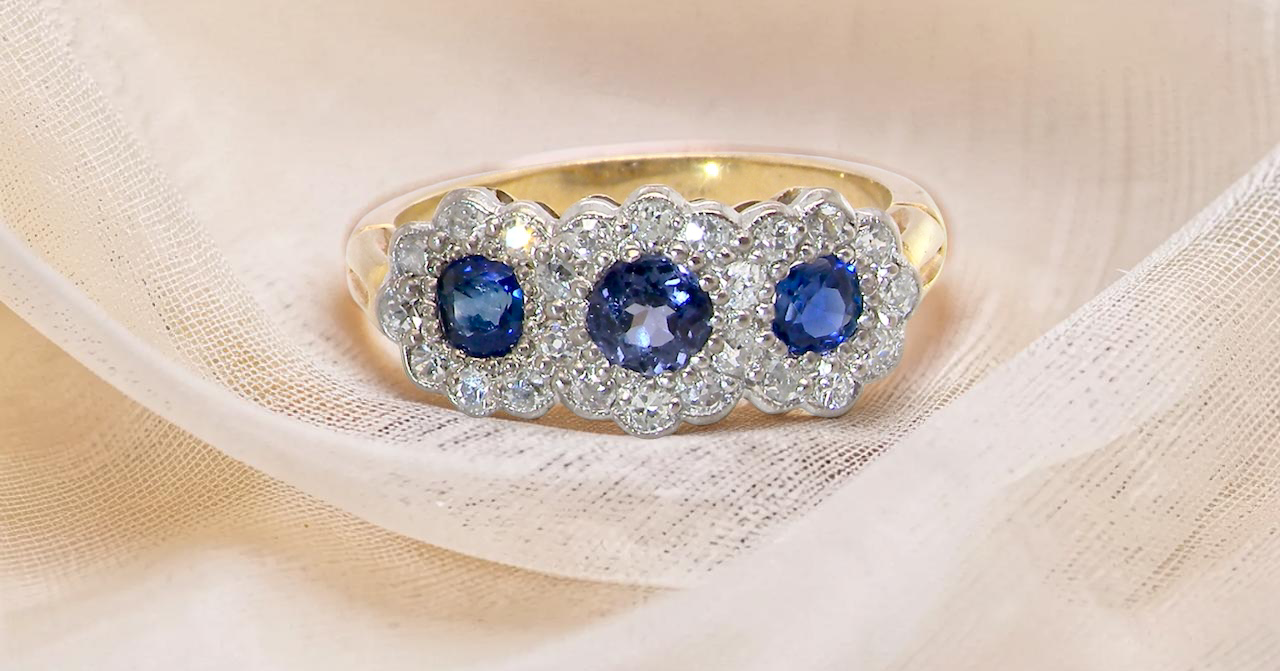 An impressive multi cluster ring. Set with three cornflower blue sapphires to each centre, 4.3mm, and each side a 3.3mm sapphire. Edwardian design