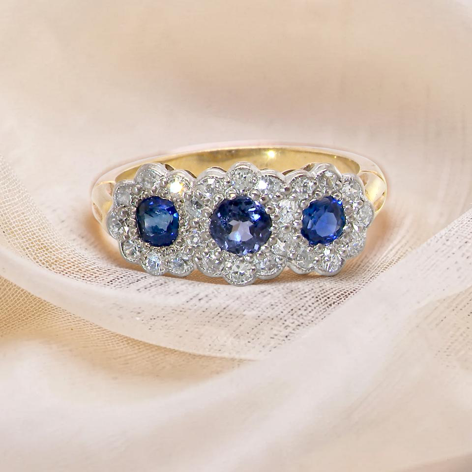 An impressive multi cluster ring. Set with three cornflower blue sapphires to each centre, 4.3mm, and each side a 3.3mm sapphire. Edwardian design