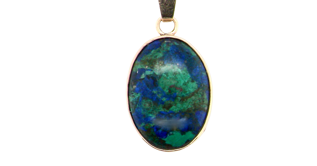 An interesting pendant set with an azurmalachite semi precious gem stone. Measures 20x15mm. Gold rim edged setting, with a V shaped bale.