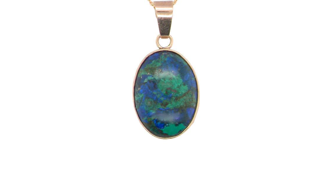 An interesting pendant set with an azurmalachite semi precious gem stone. Measures 20x15mm. Gold rim edged setting, with a V shaped bale. (tests as 9 carat gold) 