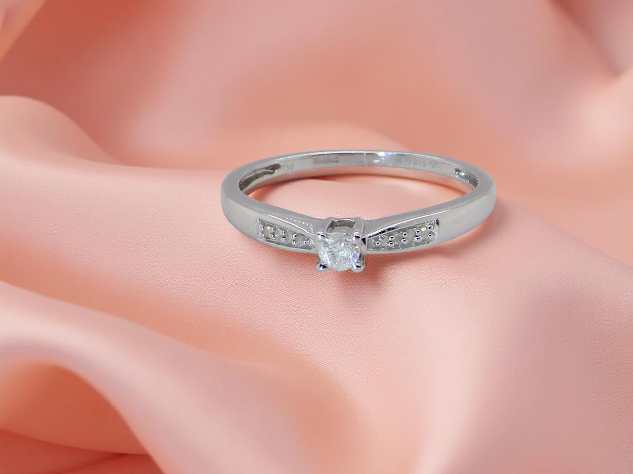 An 18 carat white gold ring set with a central round brilliant-cut diamond measuring approximately 2.8mm (0.08 carats)