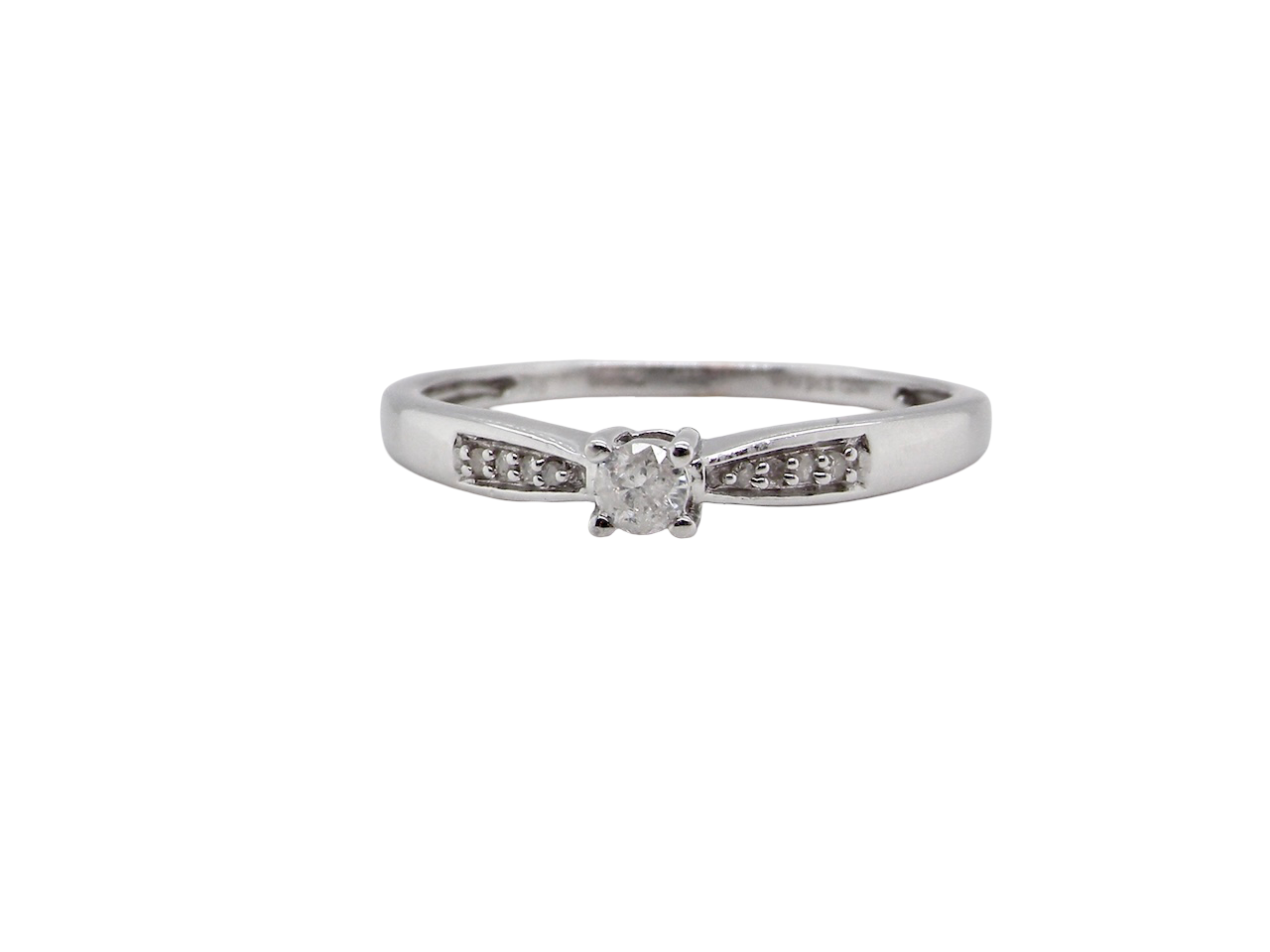 An 18 carat white gold solitaire ring set with a central round brilliant-cut diamond measuring approximately 2.8mm (0.08 carats)