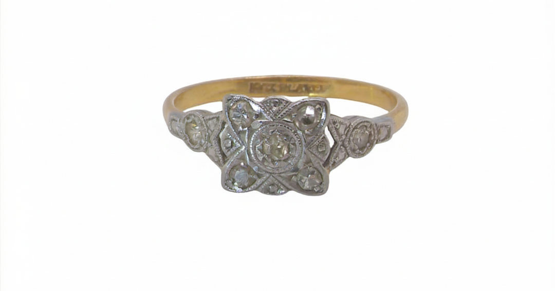 A pretty diamond cluster ring from the early part of the 20th century. A square head that has within it small white diamonds, measures 8x8mm, fancy shoulders also set with tiny diamonds.