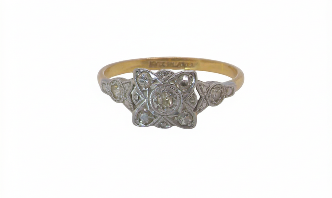 A pretty diamond cluster ring from the early part of the 20th century. A square head that has within it small white diamonds, measures 8x8mm, fancy shoulders also set with tiny diamonds.