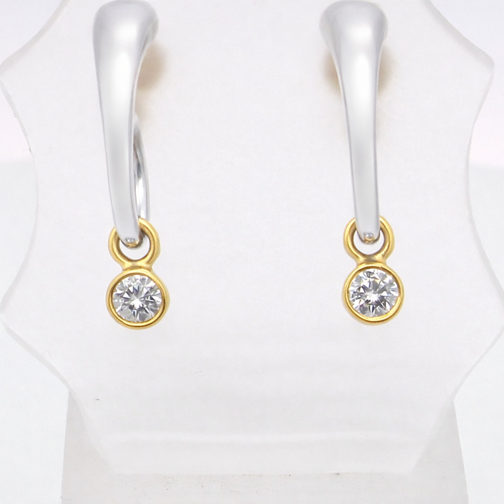 An unusual pair of earrings. The design like a French horn is fashioned in 18 carat white gold,