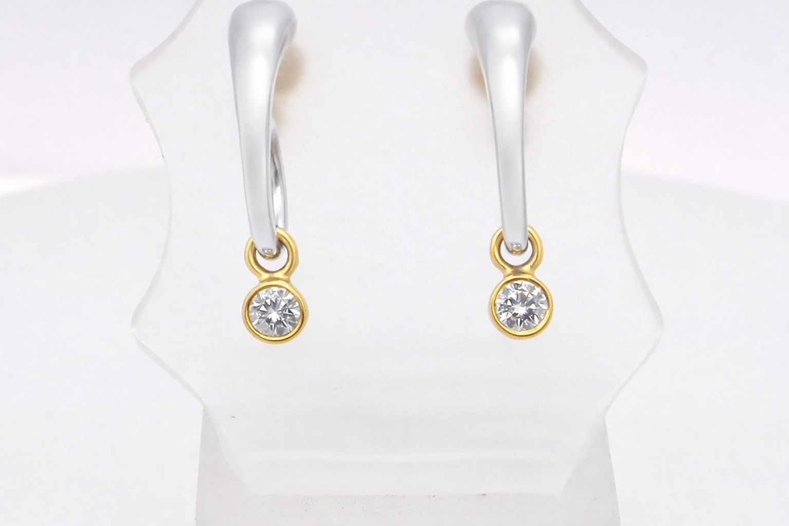 An unusual pair of earrings. The design like a French horn is fashioned in 18 carat white gold,