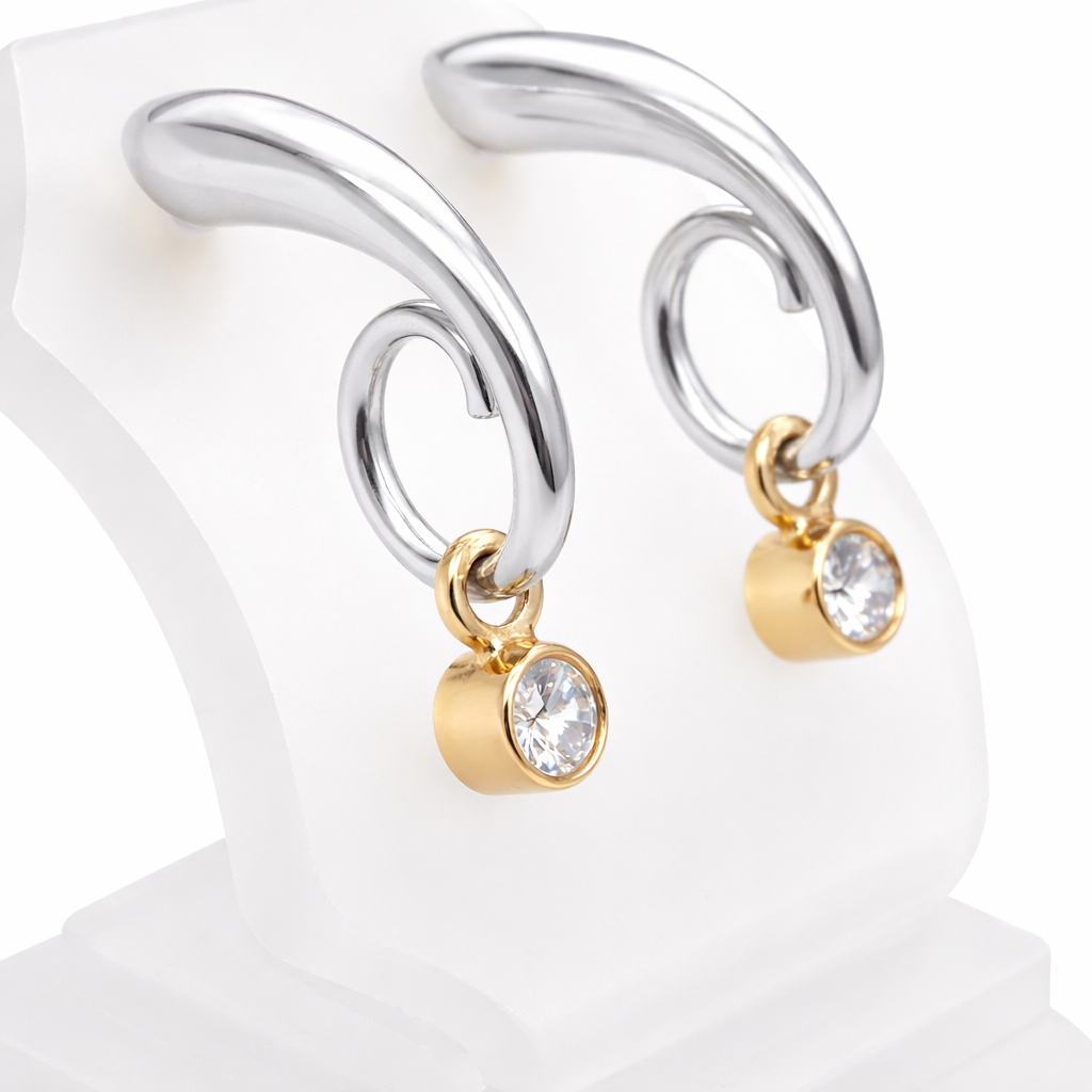 An unusual pair of earrings. The design like a French horn is fashioned in 18 carat white gold, measures 18x 10mm.